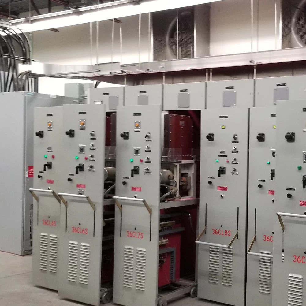 Electrical technicians working on switchgear systems in industrial facility in Alberta